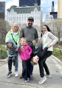 Smiling family in front of The Plaza Hotel in New York City
