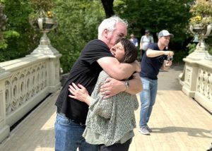 Couple sharing a joyful hug and laugh on Gapstow Bridge in Central Park