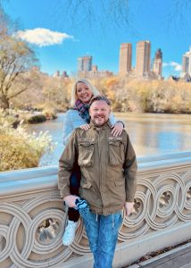 Couple posing in front of Bow Bridge in Central Park